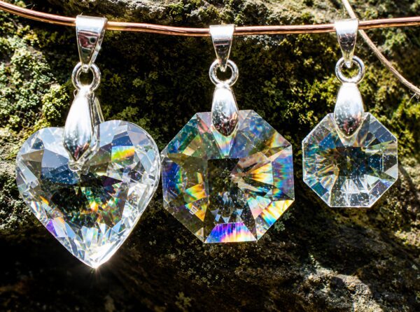 Three sparkling crystal pendants reflecting rainbow light