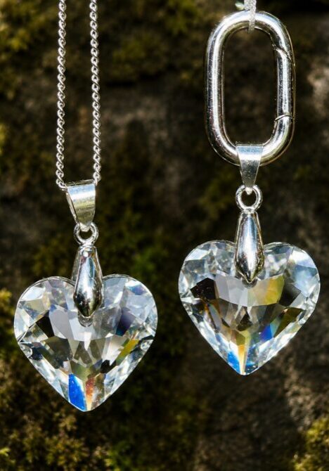 Two heart-shaped crystal pendants on chains
